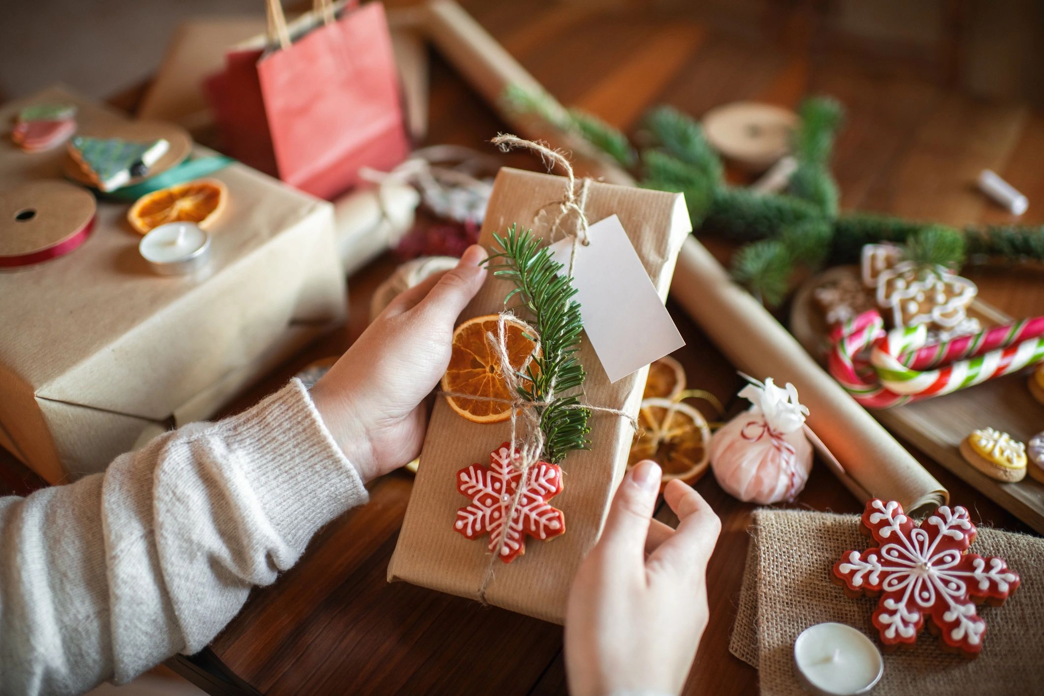 Hands wrapping a gift box with ribbon—careful finishing and presentation